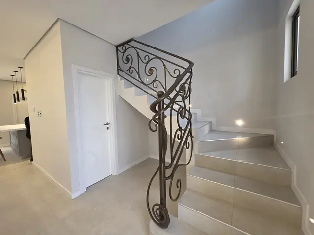 Escalera de la casa modelo con baranda de hierro forjado